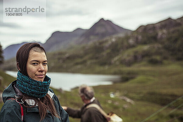 Junge Frau beim Wandern und Angeln mit der Familie in den schottischen Highlands