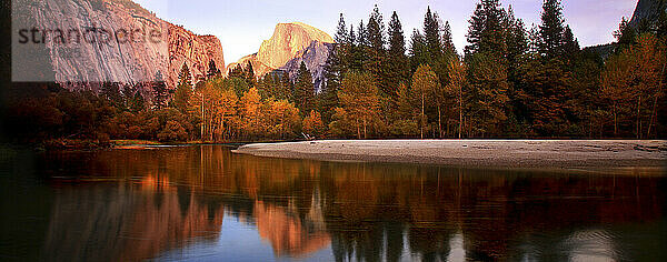 Dämmerung über dem Half-Dome-Monolithen im Yosemite-Nationalpark  Kalifornien  mit Spiegelung im Merced River  Herbst 2010.