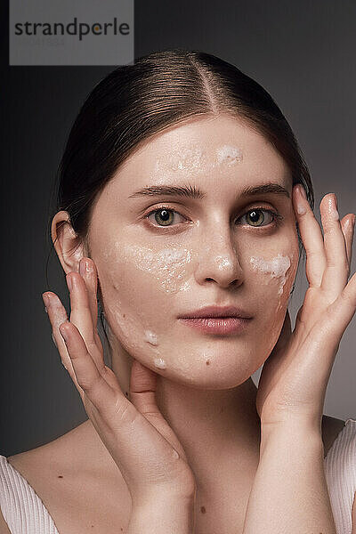 Gesichtspflege. Porträt einer Frau  die eine Maske auf saubere  hydratisierte Haut aufträgt.