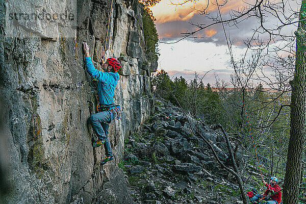 Kletterer klettert in der Abenddämmerung