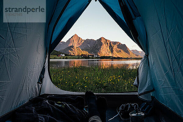 Mann entspannt sich auf einem Campingzelt mit schöner Aussicht