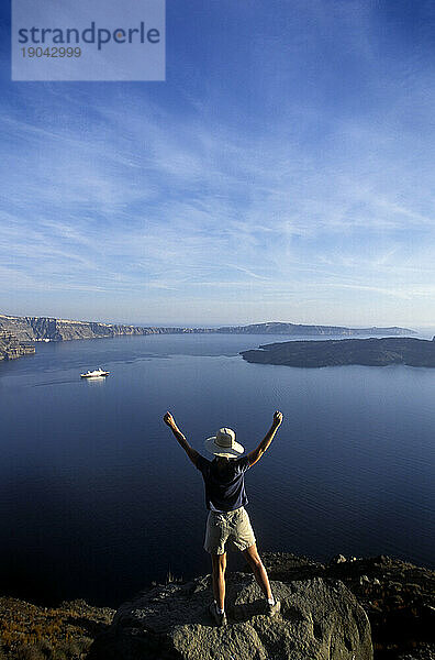 Frau feiert in der Freude  die Caldera von Santorini  Griechenland  überblicken zu können.