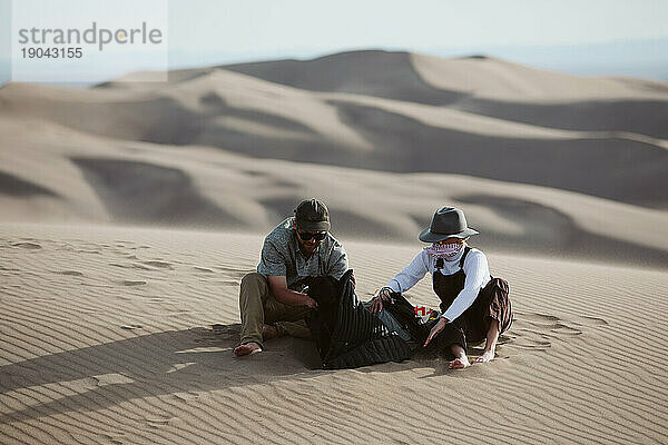 Zwei Abenteurer suchen Schutz vor dem peitschenden Wind der Sanddünen
