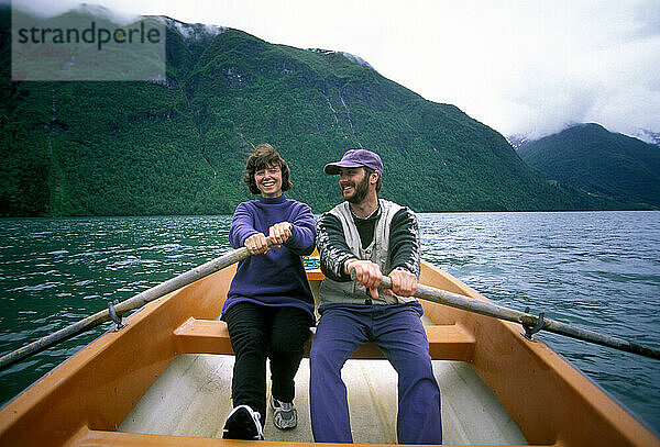 Mann und Frau rudern gemeinsam in den Fjorden Norwegens.