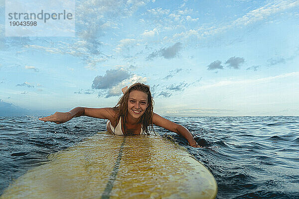 Glückliche Frau auf Surfbrett im Meer  Bali.