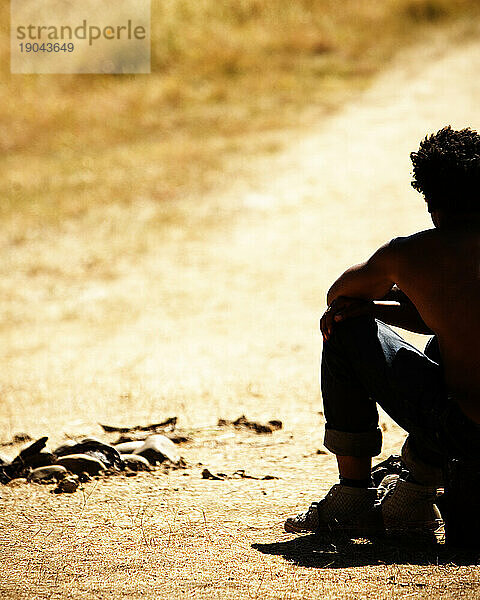 Rückansicht-Silhouette eines sitzenden Mannes im Freien.