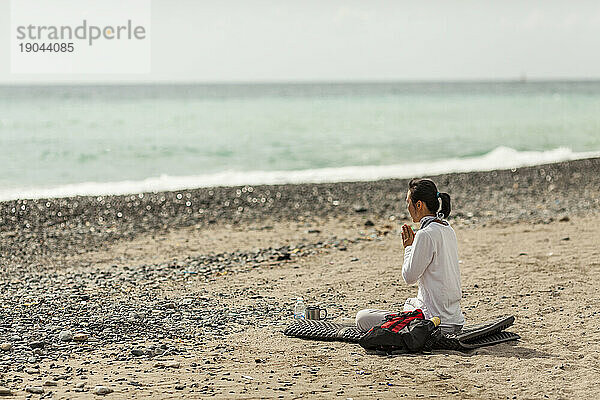 Eine Frau betet an einem Strand in Südkorea.