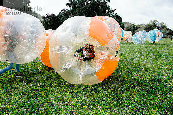 Teenie-Mädchen lächelt während eines Bubble-Football-Spiels