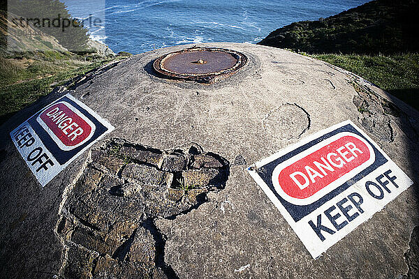 Schild „Gefahr  fernbleiben“ an einer vergrabenen Verteidigungsanlage aus Beton  Kalifornien.