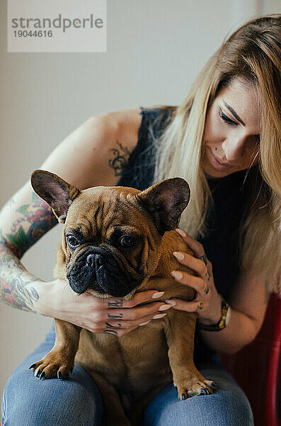 Bulldogge posiert mit tätowiertem Mädchen.