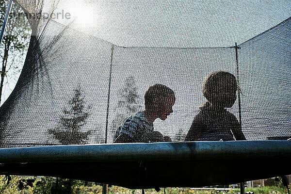 Zwei Kinder spielen auf einem Trampolin und haben Spaß