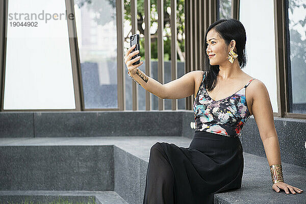 Schöne Thailänderin macht ein Selfie mit ihrem Smartphone