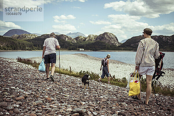 Familienspaziergang vom Picknick auf einer abgelegenen Insel mit Kiesstrand