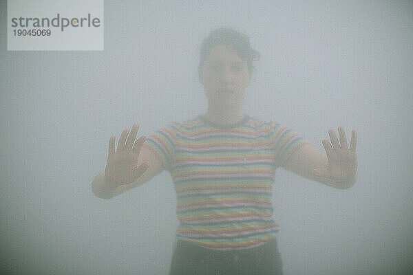 Junge Frau läuft durch Nebel in einem Park
