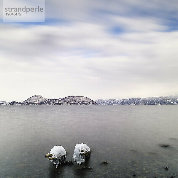 Langzeitbelichtung von mit Eis bedeckten Baumstämmen am Toya-See  Hokkaido  Japan