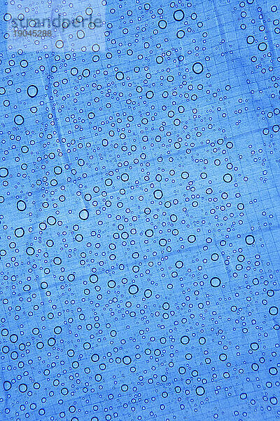 Wassertropfen auf blauer Oberfläche.