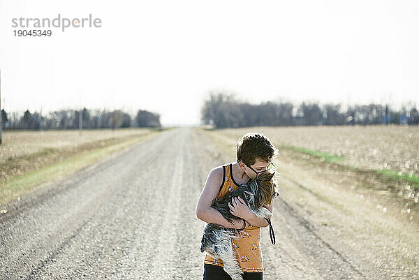 Junge zeigt seine Freundschaft mit seinem Hund in einer ländlichen Umgebung.