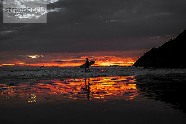 Silhouette eines Surfers bei Sonnenuntergang