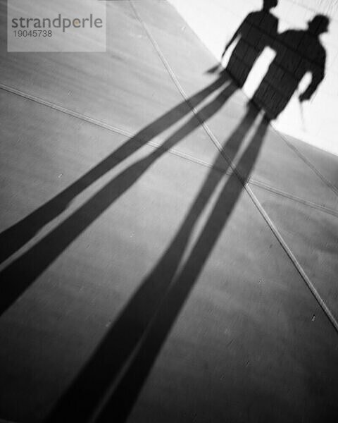Lange Schatten eines Mannes und einer Frau.