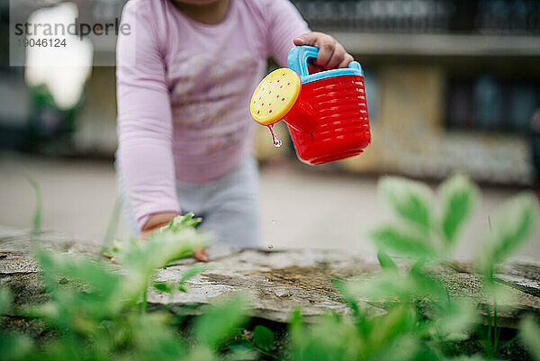 Das kleine Mädchen arbeitet im heimischen Garten