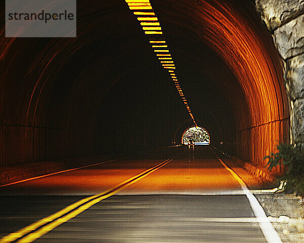 Eingang zu einem beleuchteten Straßentunnel. Foto manipuliert.