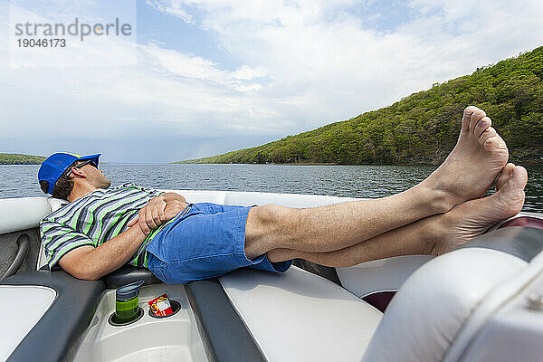 Ein Mann entspannt sich im Bug eines Motorboots am Skaneateles Lake  New York  USA