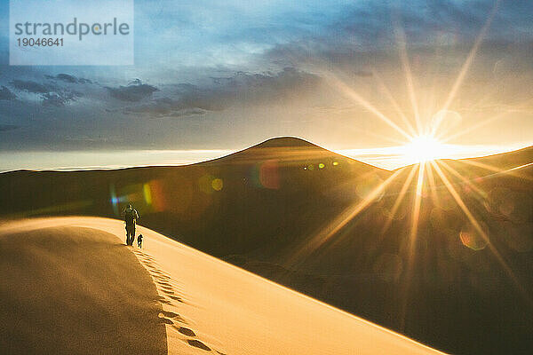 Der Sonnenuntergang über den Sanddünen beleuchtet endlich die Fußspuren der Wanderer
