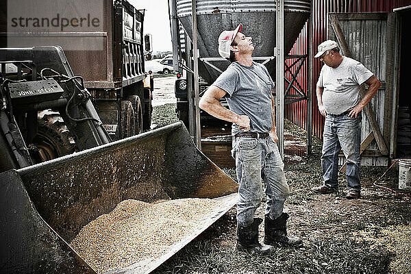 Ein Vater und sein Sohn grübeln über ein Problem mit dem Getreideheber auf der Milchfarm ihrer Familie in Keymar  Maryland.