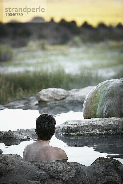 Eine Frau sitzt allein in Travertine Hot Spring  Bridgeport  Kalifornien.