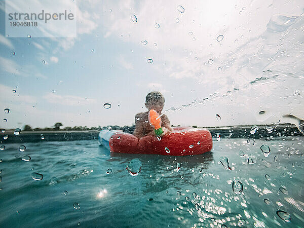 Kind im Schwimmbad schießt mit Wasserpistole