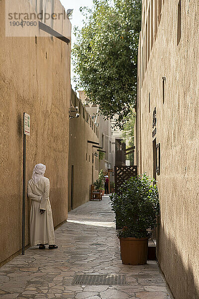 Ein Mann ruht in einer ruhigen Straße in der Altstadt von Dubai