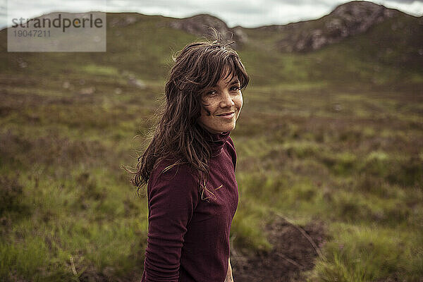 Junge Frau wandert in der schottischen Landschaft