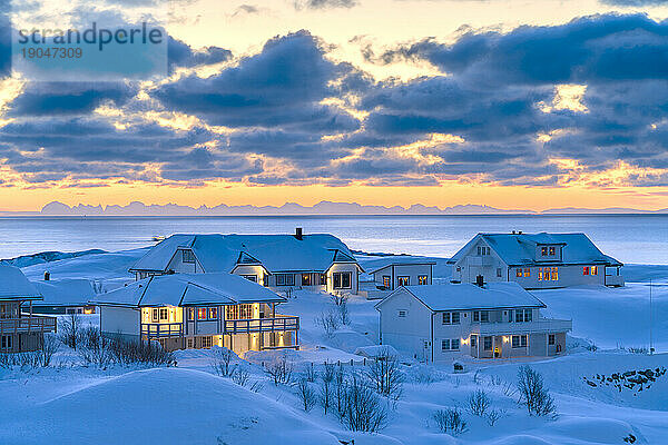 Sonnenaufgang über traditionellen Häusern am Meer  Reine  Norwegen