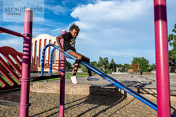 Junges afroamerikanisches Mädchen spielt auf dem Spielplatz
