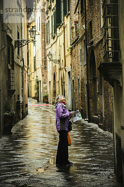 Frau steht nach Regen auf der Straße  Lucca  Toskana  Italien