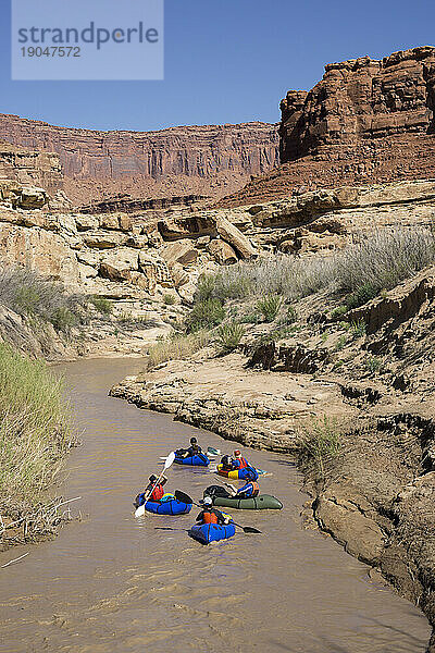 Eine Gruppe von Frauen packt Rafting auf einem Wüstenfluss.