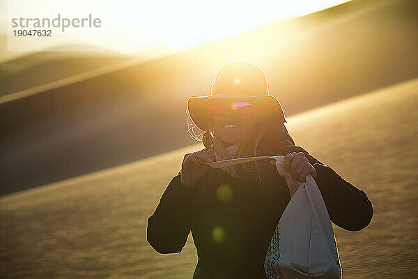 Frau Mitte 30 zur goldenen Stunde in der Sanddünenwüste von Colorado