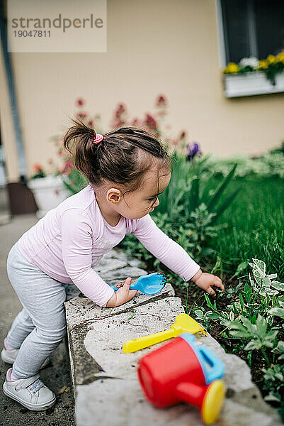 Das kleine Mädchen arbeitet im heimischen Garten