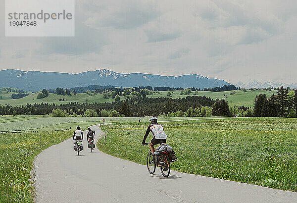 Eine Gruppe Radfahrer fährt mit dem Fahrrad in Deutschland und sieht die Alpen
