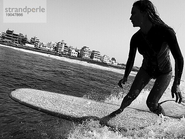 Nahaufnahme der Silhouette einer Surferin auf der Welle  schwarz und weiß