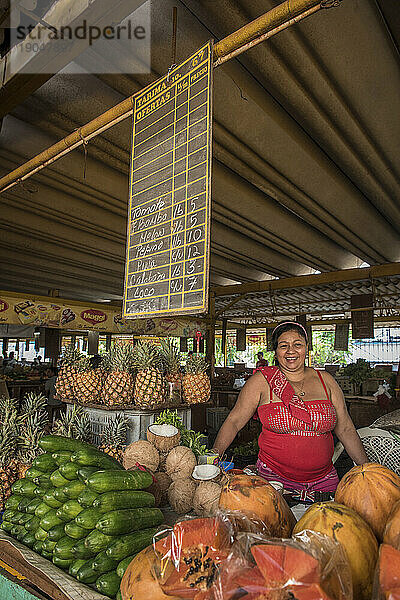 Eine lächelnde Frau  die Produkte auf dem Lebensmittelmarkt verkauft - Havanna  Kuba.