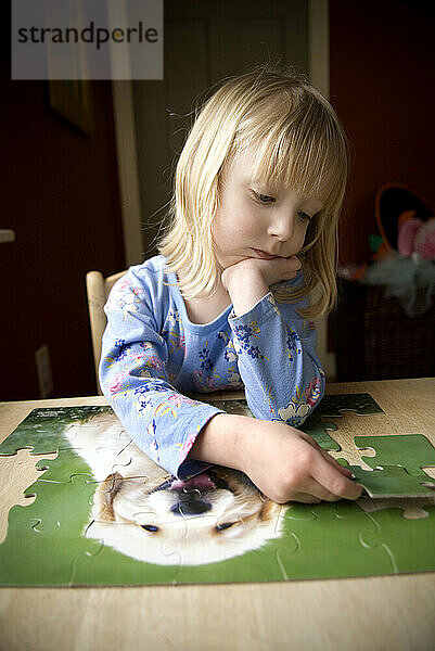 Mädchen  das Puzzle zusammensetzt.