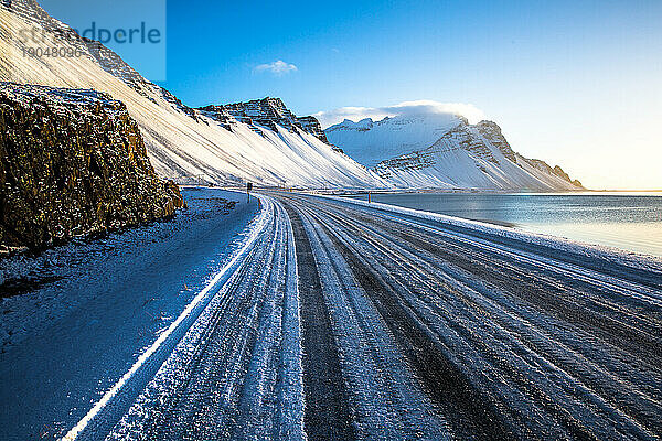 Gefrorene Straße in Island mit Bergen im Hintergrund