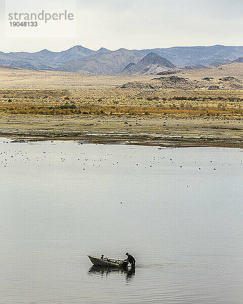 Mann und junges Mädchen starten kleines Boot im Pyramid Lake