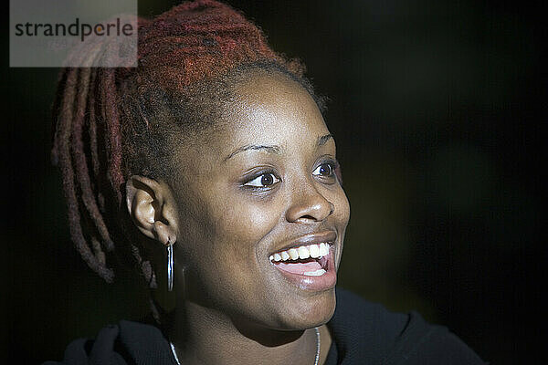 Eine lächelnde junge afroamerikanische Frau.