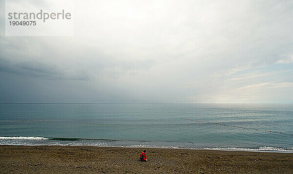 einsames Mädchen am Strand im Meer
