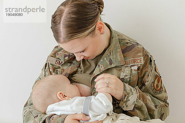 Ein aktiver Luftwaffenflieger stillt in Uniform sein Baby