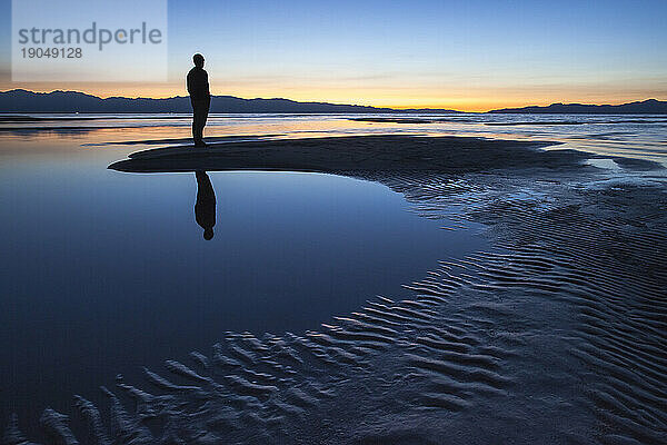 Silhouette eines Mannes an einem See.