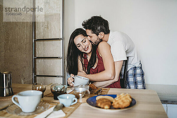 Junges glückliches Paar umarmte sich morgens im Pyjama