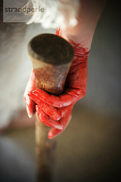 Erhöhte Rückansicht  Nahaufnahme einer blutigen Hand  die einen Holzgriff hält.